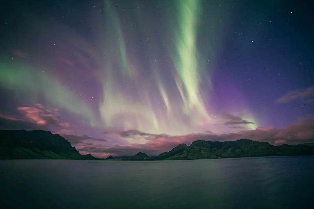 極光從厚雲的縫隙間透出來,雲層佔據大半個天空