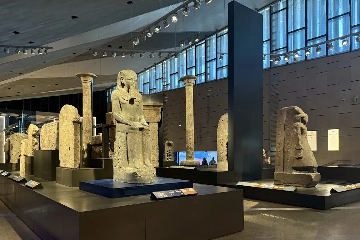 大埃及博物館的大階梯展區,兩側排列著大型法老石像,盡頭是採光玻璃